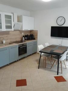 a kitchen with a table and a clock on the wall at Napvirág Vendégház in Keszthely