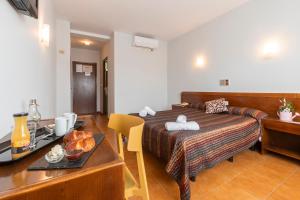 a bedroom with a bed and a table with a tray of food at Hotel Sierra de Arcos in Andorra