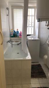 łazienka z wanną, umywalką i oknem w obiekcie Apartment Happy 11 w Pradze