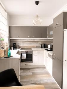 a kitchen with white cabinets and a stove top oven at New Deluxe Studio Apartment in quiet back house in Dresden
