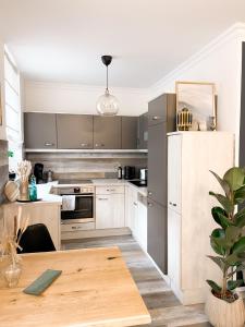 cocina con electrodomésticos de acero inoxidable y mesa de madera en New Deluxe Studio Apartment in quiet back house en Dresden