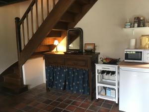 a kitchen with a staircase with a mirror and a microwave at Maison dans la prairie in Plurien