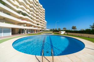 a large swimming pool in front of a building at Apartament Greta in L'Escala