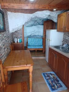 eine Küche mit einem Holztisch und einem Kühlschrank in der Unterkunft casa cueva a orilla del mar Brisas del Mar in El Escobonal