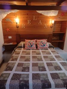 a bedroom with a bed with a wooden wall at casa cueva a orilla del mar Brisas del Mar in El Escobonal