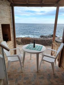 einen Tisch und zwei Stühle auf einer Terrasse mit Meerblick in der Unterkunft casa cueva a orilla del mar Brisas del Mar in El Escobonal
