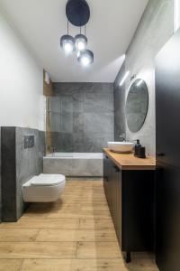 y baño con aseo, lavabo y bañera. en Apartamenty Przy IV Śluzie - LUX 50m2, en Bydgoszcz