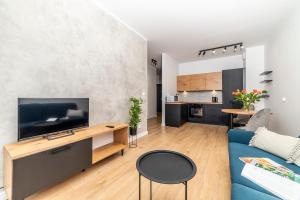salon z niebieską kanapą i kuchnią w obiekcie Apartamenty Przy IV Śluzie - LUX 50m2 w Bydgoszczy