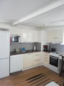 a white kitchen with white cabinets and appliances at Huoneistomajoitus Hella Härmä in Härmä