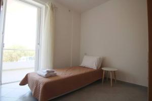 Schlafzimmer mit einem Bett und einem Fenster mit einem Tisch in der Unterkunft Melinas in Káto Alissós