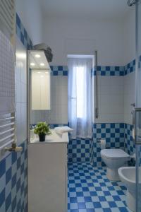 a blue and white bathroom with a toilet and a sink at Milanoverse Apartment in Milan