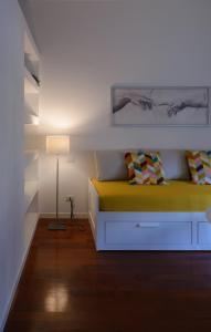 a bedroom with a yellow bed and a lamp at Milanoverse Apartment in Milan