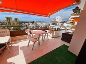 un patio con tavolo e sedie sul balcone. di wonderful penthouse with view playa las vistas ad Arona
