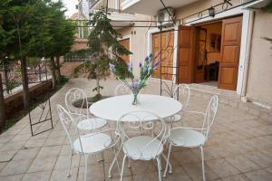 een witte tafel met stoelen en een vaas met bloemen bij Athina apartment Delphi in Delfoi