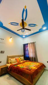 Schlafzimmer mit einem Deckenventilator und einem Bett in der Unterkunft Rudransh home stay in Rishikesh
