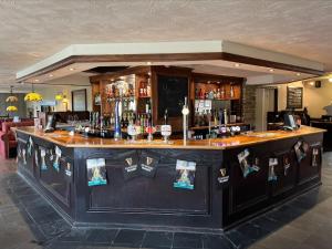 un bar con barra de madera en una habitación en Savoy Country Inn, en St Clears
