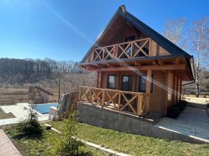 a log cabin with a large porch and a balcony at Apartmani Joka i Drvene kucice in Vrdnik