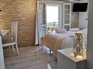 a room with a bed, chair and a window at Villa Ambra B&B in Noto