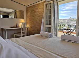 1 dormitorio con cama y vistas a la ciudad en Villa Ambra B&B, en Noto