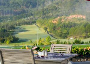 a table with two chairs and a view of a mountain at Swiss-Belresort Tuyen Lam in Da Lat