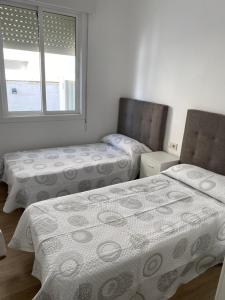 a bedroom with two beds and a window at Casa con Piscina cerca de la playa in Baiona +9 photos