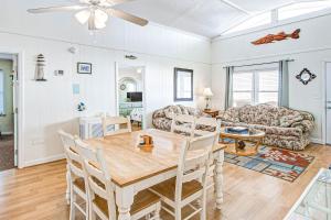 a dining room and living room with a table and chairs at Charisma in Holden Beach