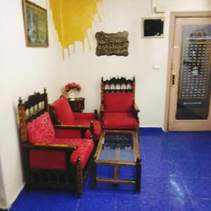 ein Wohnzimmer mit 2 Stühlen und einem Tisch in der Unterkunft Elredy's apartments the blue edition in Kairo