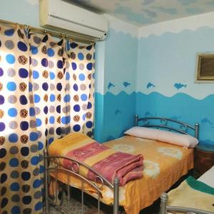 a bedroom with a bed and a curtain with bats on the wall at Elredy's apartments the blue edition in Cairo