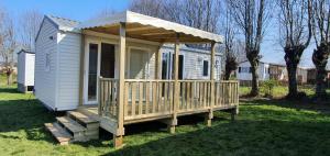 een tiny house met een veranda en een terras bij Camping Les Sources Liencourt in Liencourt