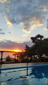 a view of the sunset from a swimming pool at Cachoeira do santo Antônio in Delfinópolis