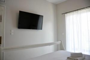 sypialnia z telewizorem na ścianie i łóżkiem w obiekcie Apartment beach house w Chalkidzie