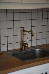 a kitchen sink with a brass faucet at Apartment beach house in Chalkida