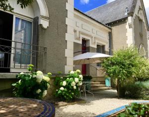 une maison avec une table et un parasol devant elle dans l'établissement La Villa de Chinon, à Chinon