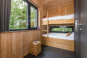 ein Schlafzimmer mit Etagenbetten in einem winzigen Haus in der Unterkunft Lütetsburg Lodges in Lütetsburg