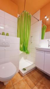 baño con aseo y cortina de ducha verde en Ferienpark D09-008 Ferienpark, en Heiligenhafen