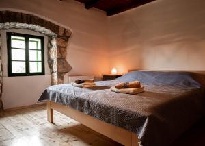 a bedroom with a bed with two towels on it at Holiday House Antica for 6 persons green surroundings of the island of Cres in Vidović