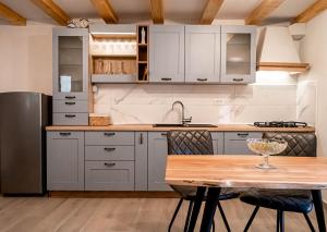 a kitchen with white cabinets and a wooden table at Holiday House Antica for 6 persons green surroundings of the island of Cres in Vidović