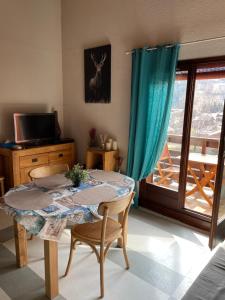 une chambre avec une table, des chaises et une fenêtre dans l'établissement Studio « Au beau soleil », à Saint-Gervais-les-Bains