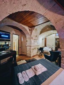 ウチヒサールにあるMimi Cappadocia Luxury Cave Hotelのベッドルーム1室(タオル付)