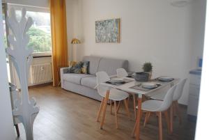 a living room with a table and chairs and a couch at RAGGIO DI SOLE - pool, tennis, parking, sea view & relax in Rapallo