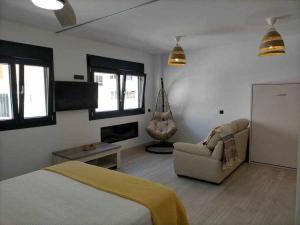 1 dormitorio con 1 cama, 1 sofá y 1 silla en Acogedor apartamento en la playa de Cádiz, en Cádiz