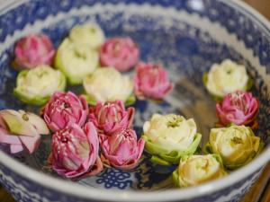 un ramo de flores en un tazón azul y blanco en Ban U Thong Accommodations, en Phra Nakhon Si Ayutthaya