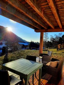 einen Picknicktisch und Stühle unter einem Holzdach in der Unterkunft Votre studio balnéo bien-être à la montagne in Thollon + 16 Fotos