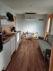 a kitchen and living room with a couch and a table at Votre studio balnéo bien-être à la montagne in Thollon