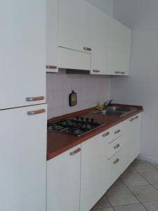 een witte keuken met een wastafel en een fornuis bij Villa Giulia in Grado