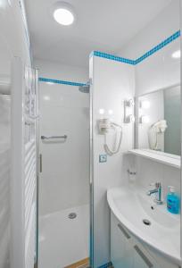 a white bathroom with a shower and a sink at Stylish studio Dare next to the City walls in Dubrovnik