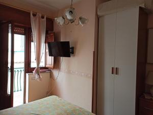 ジャルディーニ・ナクソスにあるRecanati Apartamentのベッドルーム1室(ベッド1台、壁掛けテレビ付)