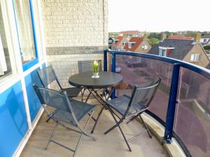 a table and chairs on a balcony with a view at Petten Beach 17 in Petten +3 photos