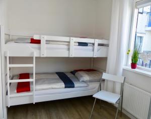 a room with bunk beds with a chair and a window at Petten Beach 17 in Petten