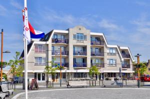 a large building with a flag in front of it at Petten Beach 17 in Petten
